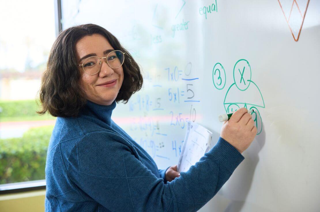 RSM teacher smiling at whiteboard